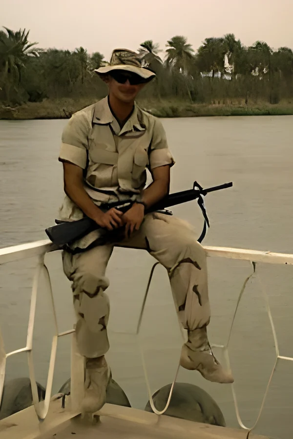 Nick in desert cammies on a boat in Iraq, 2003
